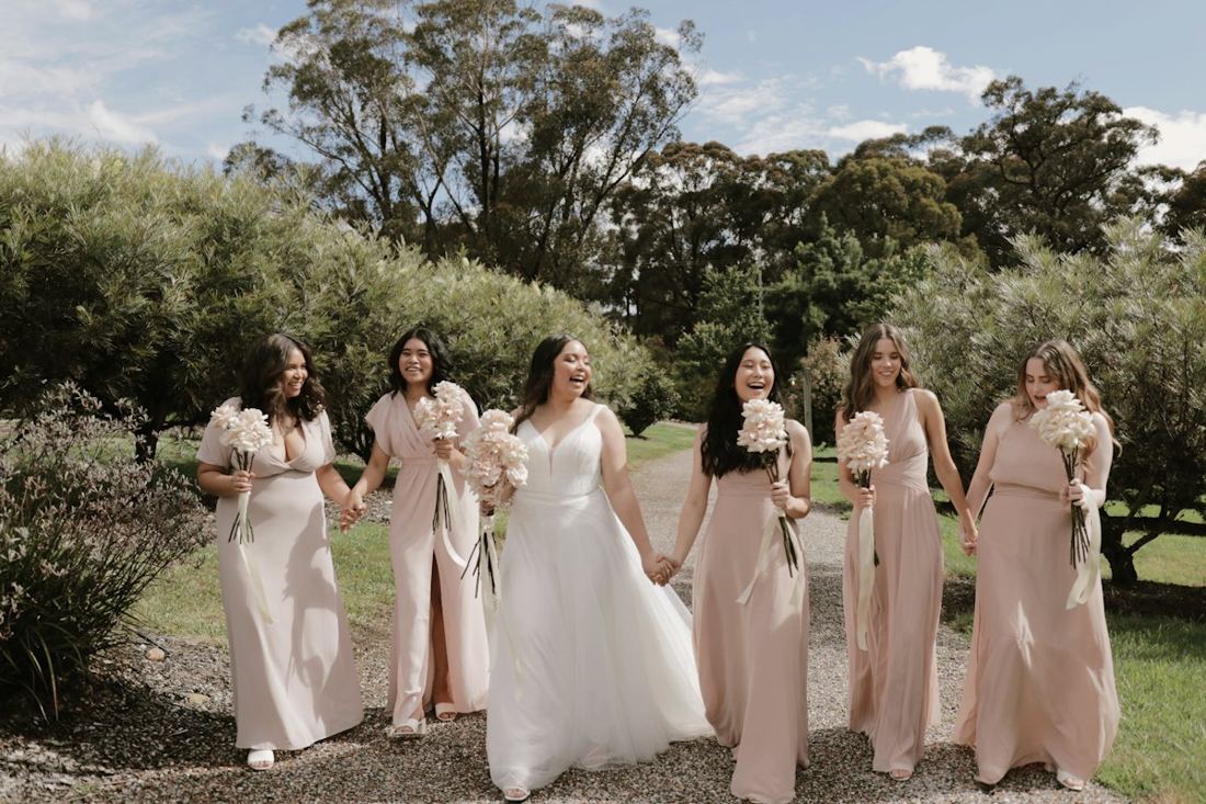 Bride and bridesmaids walking together outdoors