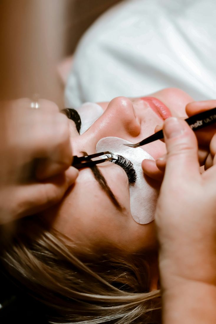 Lash technician applying eyelash extensions